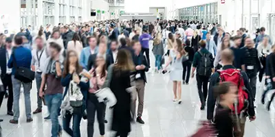 Viele Menschen laufen einen langen breiten Gang entlang.